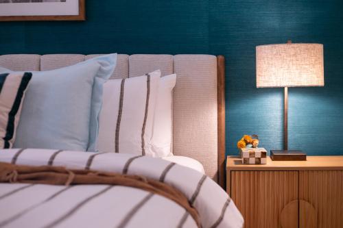 a bedroom with a bed with a lamp on a table at Monsoon Luxury Apartment in Port Douglas