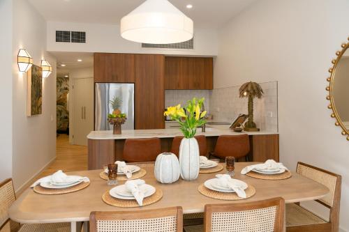 a dining room with a wooden table and chairs at Monsoon Luxury Apartment in Port Douglas
