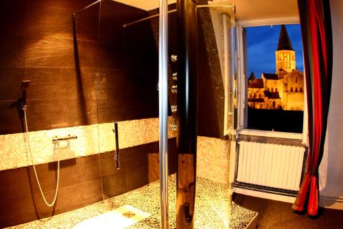 a bathroom with a shower with a view of a castle at Hotel de la Basilique in Paray-le-Monial