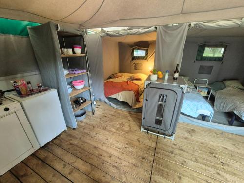 une chambre avec un lit et un poêle dans une tente dans l'établissement Camping les Peupliers, à Vendays-Montalivet