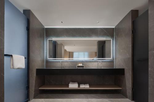 a bathroom with a sink and a mirror at Guanran Hotel - Yongningmen Subway Station in Xi'an