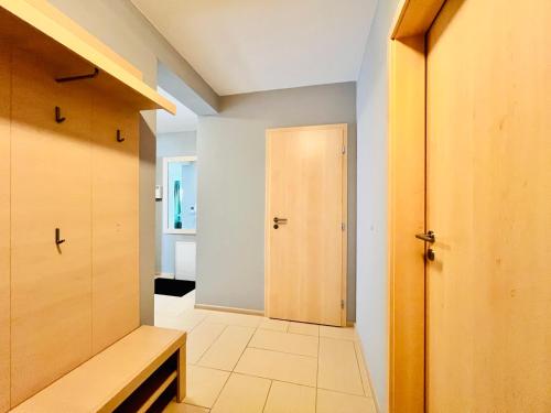 a hallway with a wooden door and a room with at Bart Apatrments Veľká Lomnica Apartman B in Veľká Lomnica