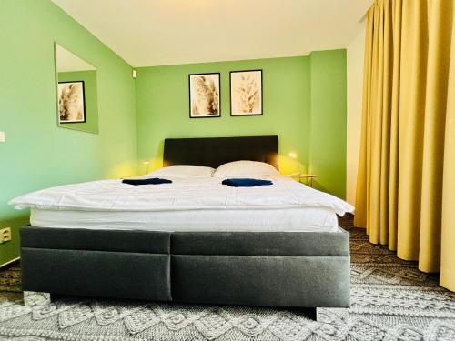a bedroom with a large bed with green walls at Bart Apatrments Veľká Lomnica Apartman B in Veľká Lomnica