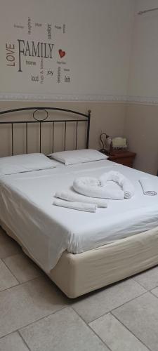 a bed with white sheets and towels on it at L'Oasi in Zagarolo