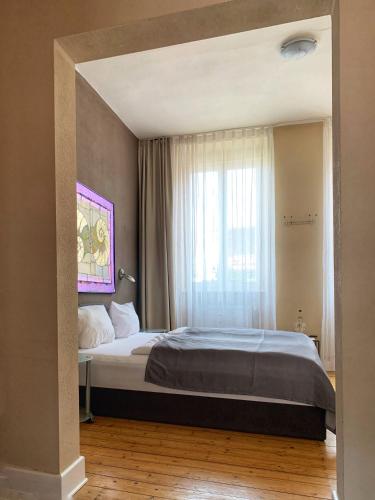Un dormitorio con una cama grande y una ventana. en Augusta Trarbach, en Traben-Trarbach