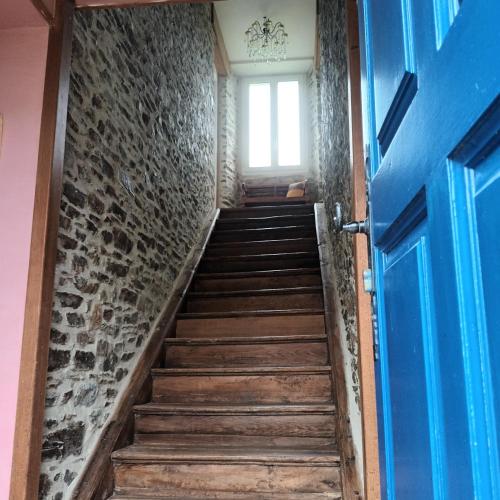 un escalier avec une porte bleue et une fenêtre dans l'établissement Chambre des bords de Siame, à Gratot