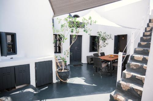 un patio con una mesa y un árbol en una olla en 1906 Cave Villa, en Pirgos