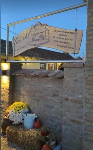 a sign that is hanging over a brick wall at Seosko turističko domaćinstvo Biser in Stara Bingula