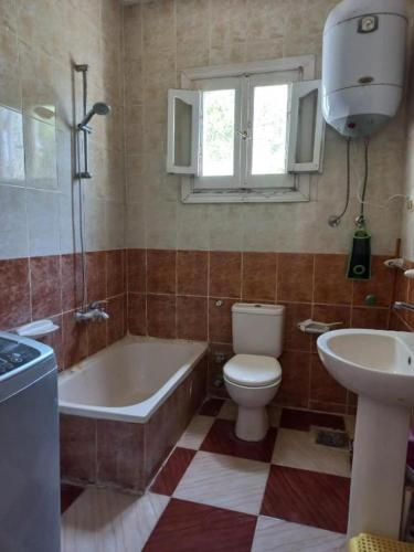 a bathroom with a tub and a toilet and a sink at Room in 2 minutes from the beach in El Alamein