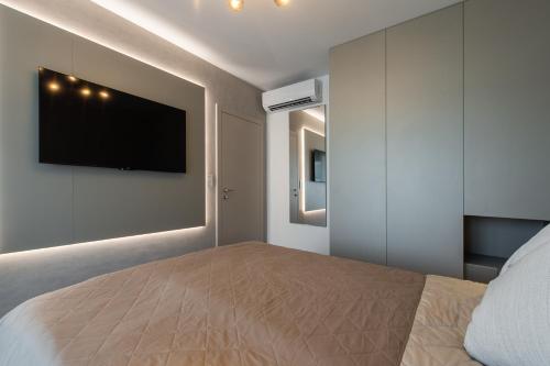a bedroom with a bed with a television on the wall at Nikas Eurovea Apartments - free parking in Bratislava