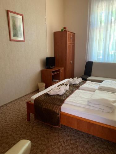 a hotel room with a bed and a couch at Szent István Wellness Panzió in Makó