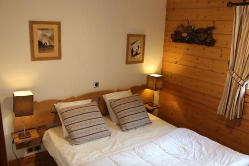 une chambre avec un lit avec deux oreillers dessus dans l'établissement Reine des Prés, à Samoëns