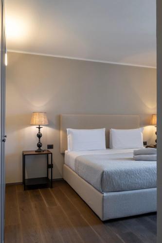 a bedroom with a bed and a table with a lamp at Palazzo Massaini - Le Scuderie in Pienza