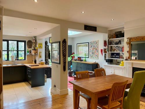 a kitchen with a wooden table and a dining room at Beautiful Victorian House in Central Chelmsford in Chelmsford