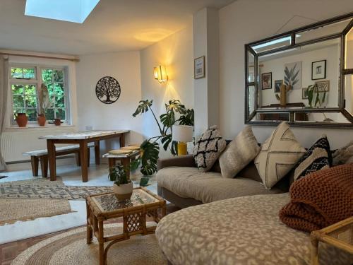 a living room with a couch and a mirror at Picturesque Cottage in Oving- cosy pub & beaches in Oving