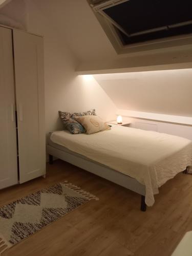 ein Schlafzimmer mit einem Bett mit einer Lampe darauf in der Unterkunft L' Évasion en plein air in Fontenay-sur-Loing