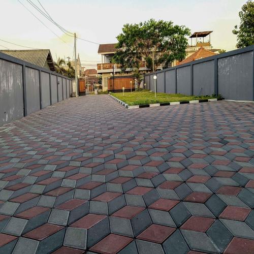 a brick walkway with a fence and a wall at Nawasena Homey Syariah near Bandara Adisucipto 4 Mitra RedDoorz in Potrojayan