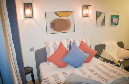 Cette chambre comprend un lit avec des oreillers colorés. dans l'établissement Private apartment in paris Defense, à Courbevoie