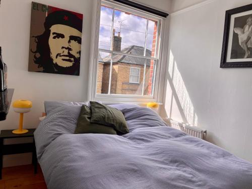 a bed sitting in a room with a window at Beautiful Victorian House in Central Chelmsford in Chelmsford