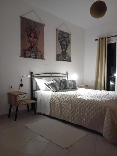 a bedroom with a bed and two pictures on the wall at Mondo Piccolino in Samos