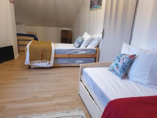 une chambre avec deux lits et un parquet dans l'établissement la maison de noemia à Gerardmer, à Gérardmer