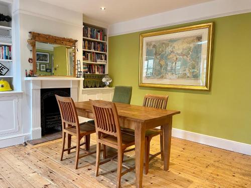 a dining room with a wooden table and chairs at Beautiful Victorian House in Central Chelmsford in Chelmsford