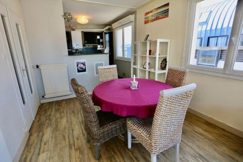 une salle à manger avec une table et des chaises roses dans l'établissement Joli appartement Centre-ville, à Brest