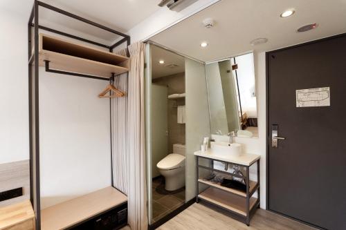 a bathroom with a toilet and a sink and a mirror at Green Hotel - Chiayi in Chiayi City