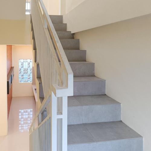 a staircase in a house with white walls at Nawasena Homey Syariah near Bandara Adisucipto 4 Mitra RedDoorz in Potrojayan