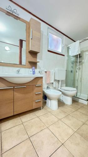 a bathroom with a sink and a toilet and a shower at Onda Marina Apartments in Forio d'Ischia