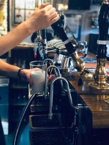 a person is making a cup in a machine at The Orange Tree Hotel in Kirkby Lonsdale
