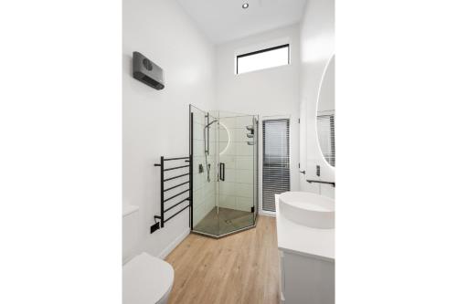 a bathroom with a glass shower and a sink at Boutique One Bedroom Haven in Wanaka