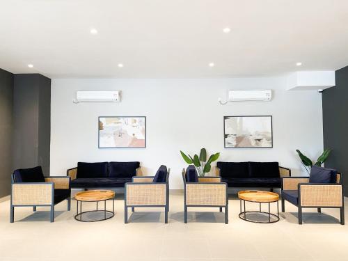 a living room with couches and chairs and tables at Veranda-2BR,4pax I 5mins to CIQ and KSL I Fast-Wifi in Johor Bahru
