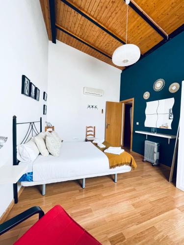 a bedroom with a white bed and blue walls at Apartamentos Turísticos Architettura Úbeda in Úbeda