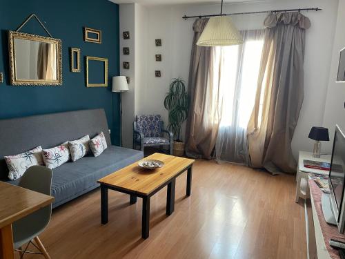 a living room with a couch and a table at Apartamentos Turísticos Architettura Úbeda in Úbeda