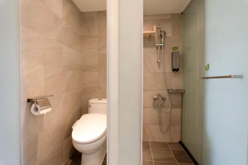 a bathroom with a toilet and a shower at Green Hotel - Chiayi in Chiayi City