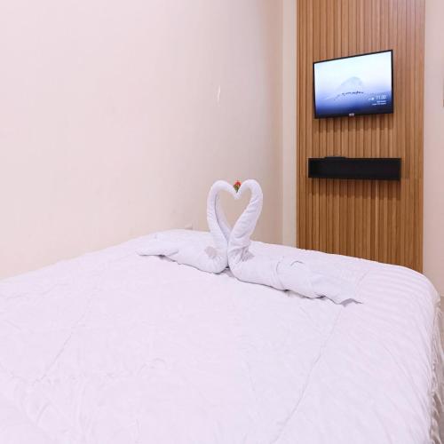 a bed with two swans made to look like hearts at Nawasena Homey Syariah near Bandara Adisucipto 4 Mitra RedDoorz in Potrojayan