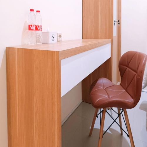 a desk with a chair and water bottles on it at Nawasena Homey Syariah near Bandara Adisucipto 4 Mitra RedDoorz in Potrojayan
