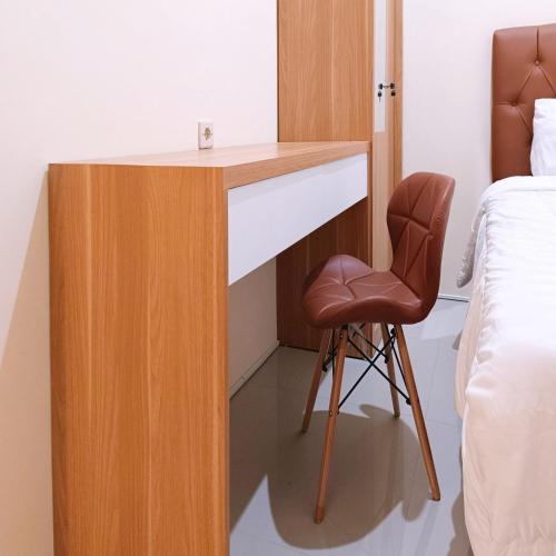 a desk in a bedroom with a chair next to a bed at Nawasena Homey Syariah near Bandara Adisucipto 4 Mitra RedDoorz in Potrojayan