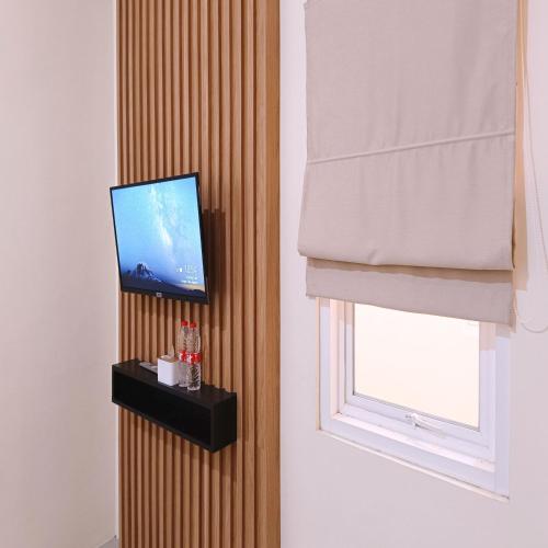 a living room with a television and a window at Nawasena Homey Syariah near Bandara Adisucipto 4 Mitra RedDoorz in Potrojayan