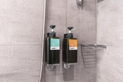 two bottles ofodorizers on the wall of a bathroom at The Galerie Hotel in Taichung