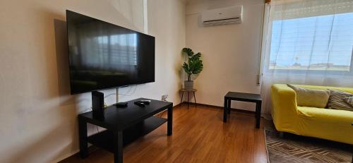 a living room with a large flat screen tv on the wall at Modern 3 Bed Flat - Beaches, Expo & City Fun - Your Gateway to Lisbon in Montijo