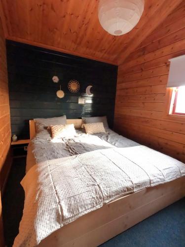 a bedroom with a bed in a wooden wall at Hip Huisje van Hout in Gramsbergen
