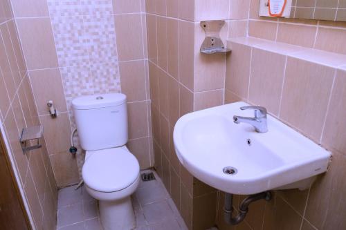 a bathroom with a white toilet and a sink at The Enviro Nusantara By Reccoma in Cibeber