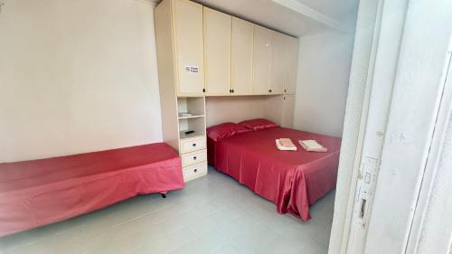 a small bedroom with two beds and cabinets at Onda Marina Apartments in Ischia