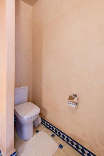 a bathroom with a toilet and a toilet paper dispenser at Riad Asilah 32 in Asilah