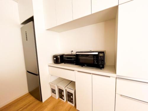 a kitchen with a microwave and a refrigerator at Niseko White Villas1 in Niseko