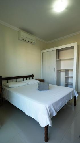 a bedroom with a large white bed in a room at Edifício Costa Mar - Centro de Bombinhas in Bombinhas