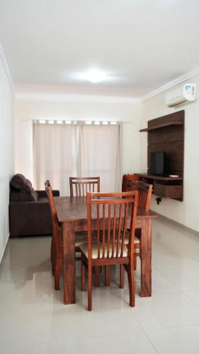 a wooden table and chairs in a living room at Edifício Costa Mar - Centro de Bombinhas in Bombinhas