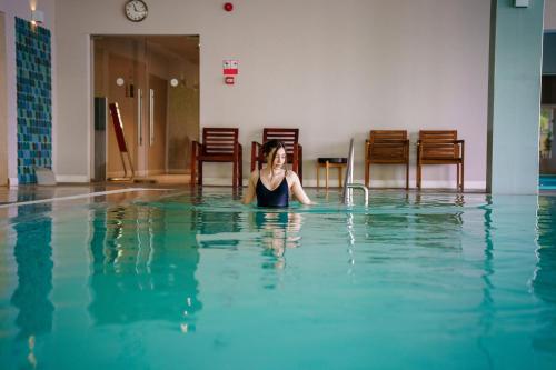 a woman laying in the water in a swimming pool at Bacolux Diana, Herculane in Băile Herculane